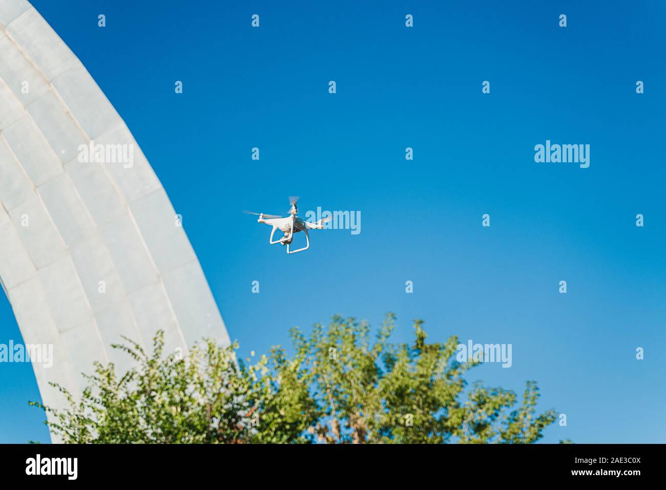 Drone è volare sotto la città nel cielo blu. Antenna Uncrewed veicolo è fare foto e film video a comando remoto del pilota. Imag orizzontale Foto Stock