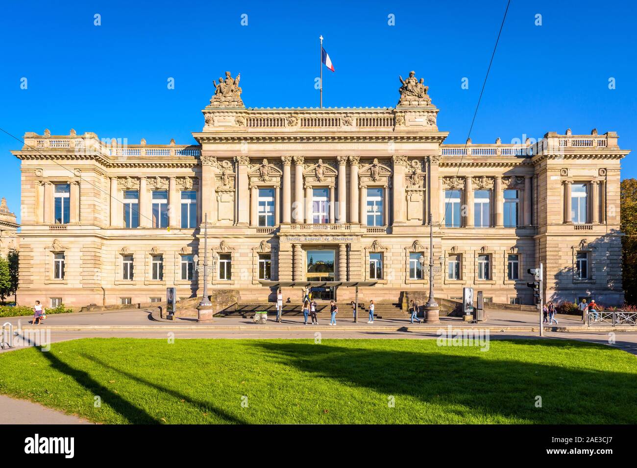 Vista frontale del Teatro Nazionale di Strasburgo, in stile neo-rinascimentale palazzo costruito sotto l'impero tedesco e persone in attesa alla fermata del tram. Foto Stock