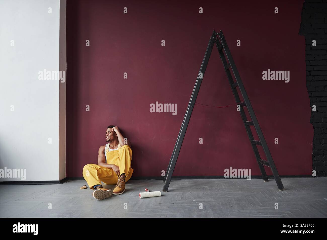 È stato facile. Giovane africana lavoratore americano in giallo sono uniformi in alcuni job Foto Stock
