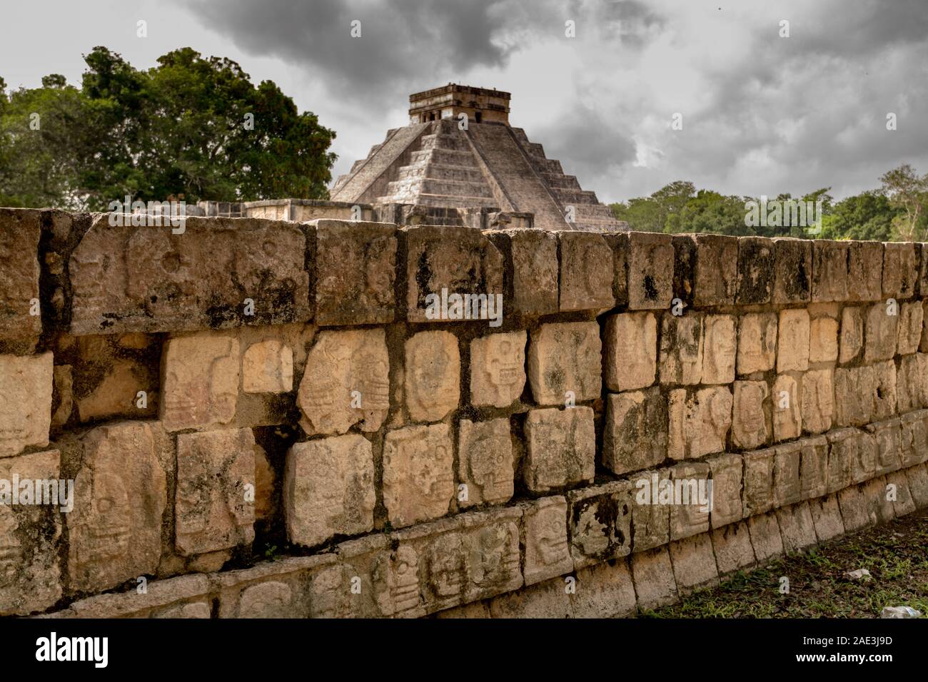 El Castillo (Tempio di Kukulcan) con tzompantli o piattaforma di cranio in primo piano Foto Stock