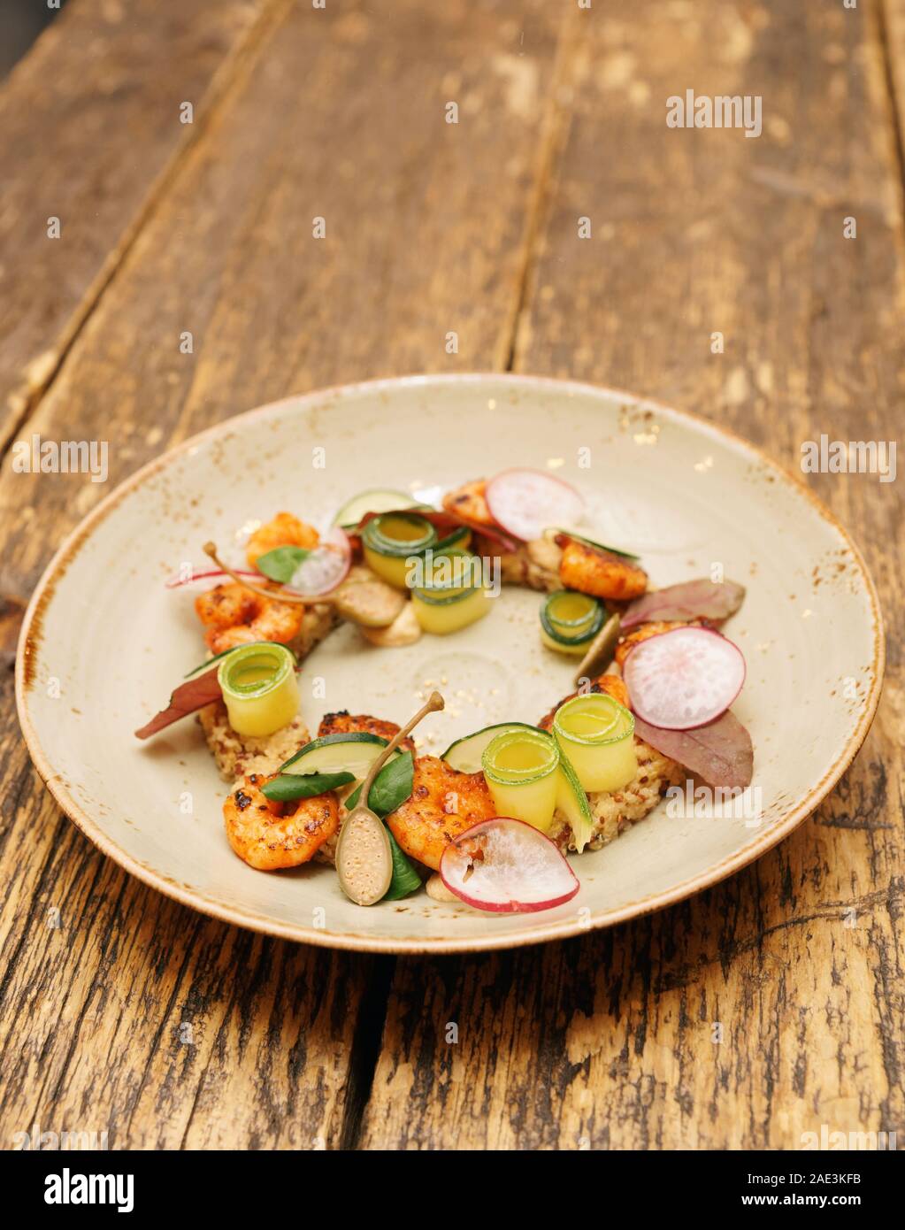 Piatto di motorino di avviamento con gamberi e zucchine e la quinoa sul tavolo di legno, tonica immagine Foto Stock