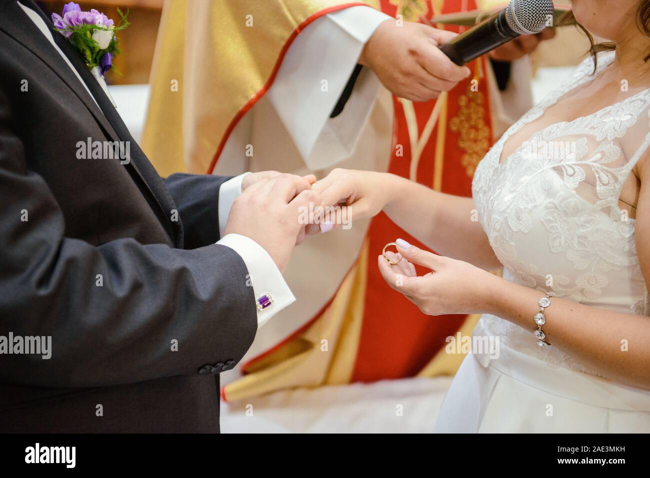 La sposa e lo sposo durante la cerimonia di nozze mettere gli anelli di nozze sulla loro dita. Foto Stock