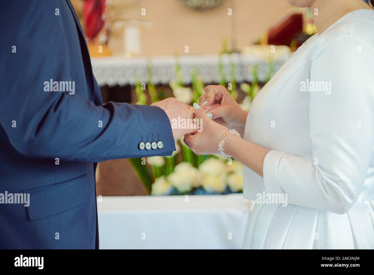 La sposa e lo sposo durante la cerimonia di nozze mettere gli anelli di nozze sulla loro dita. Foto Stock