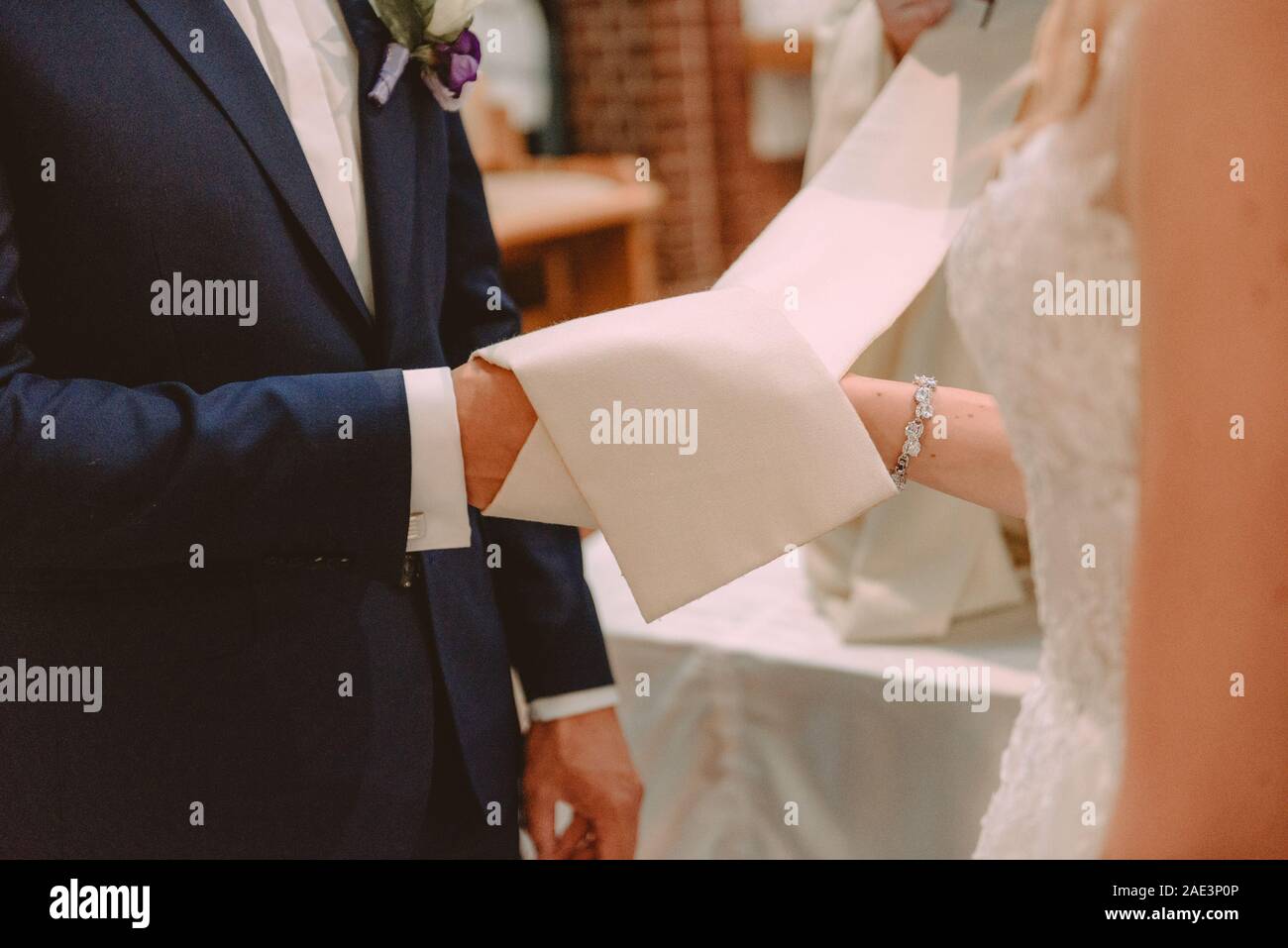 La sposa e lo sposo durante la cerimonia di nozze mettere gli anelli di nozze sulla loro dita. Foto Stock