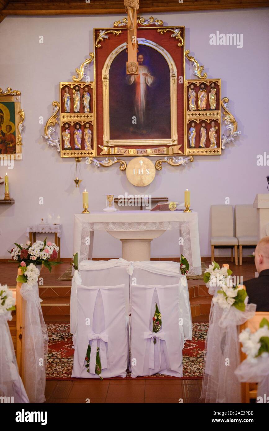 Chiesa Santuario prima di una cerimonia di matrimonio. Sedie vuote per la sposa e lo sposo Foto Stock