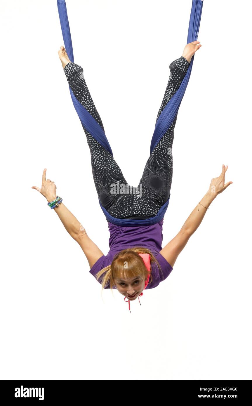 Giovane donna antenna pratiche anti-gravità lo yoga con amaca in un bianco studio. Concetto di salute mentale e fisica di un armonia vivere Foto Stock