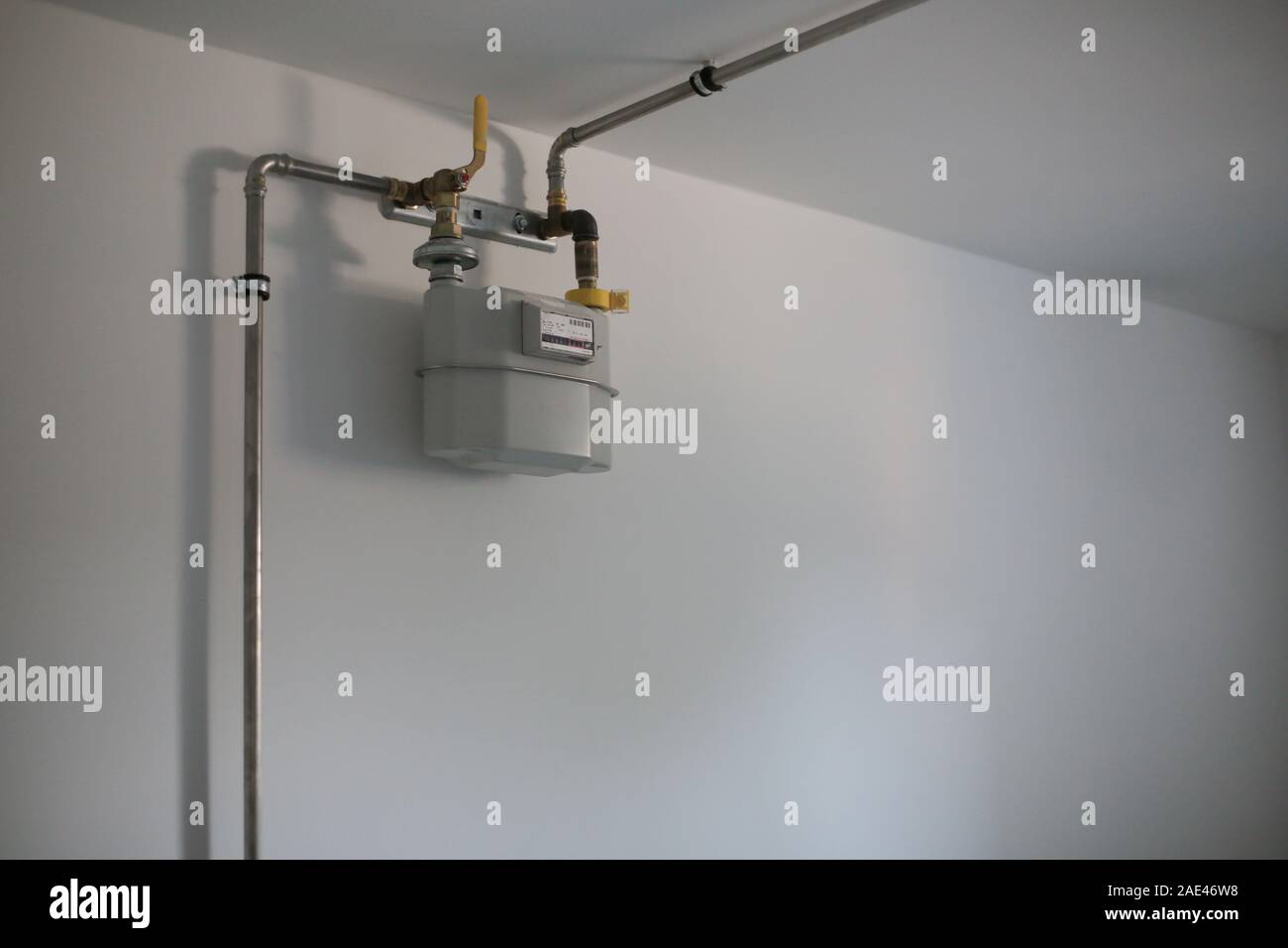 Tubazioni del gas naturale ed il misuratore sul muro bianco in casa Foto Stock