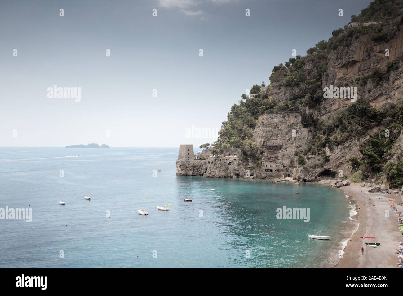 Spiaggia di positano con un vecchio look out torre in background Foto Stock