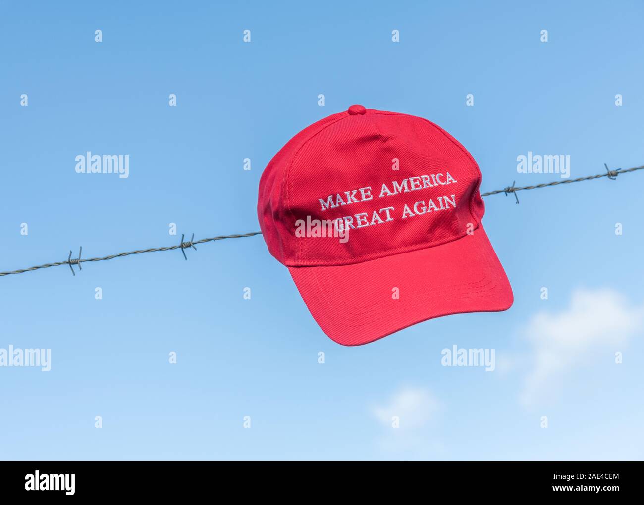 Donald Trump sostenitori" rosso maga campagna hat / tappo sul filo spinato + blu cielo. Metafora Trump negli Stati Uniti la politica di immigrazione, Trump muro di confine. Foto Stock