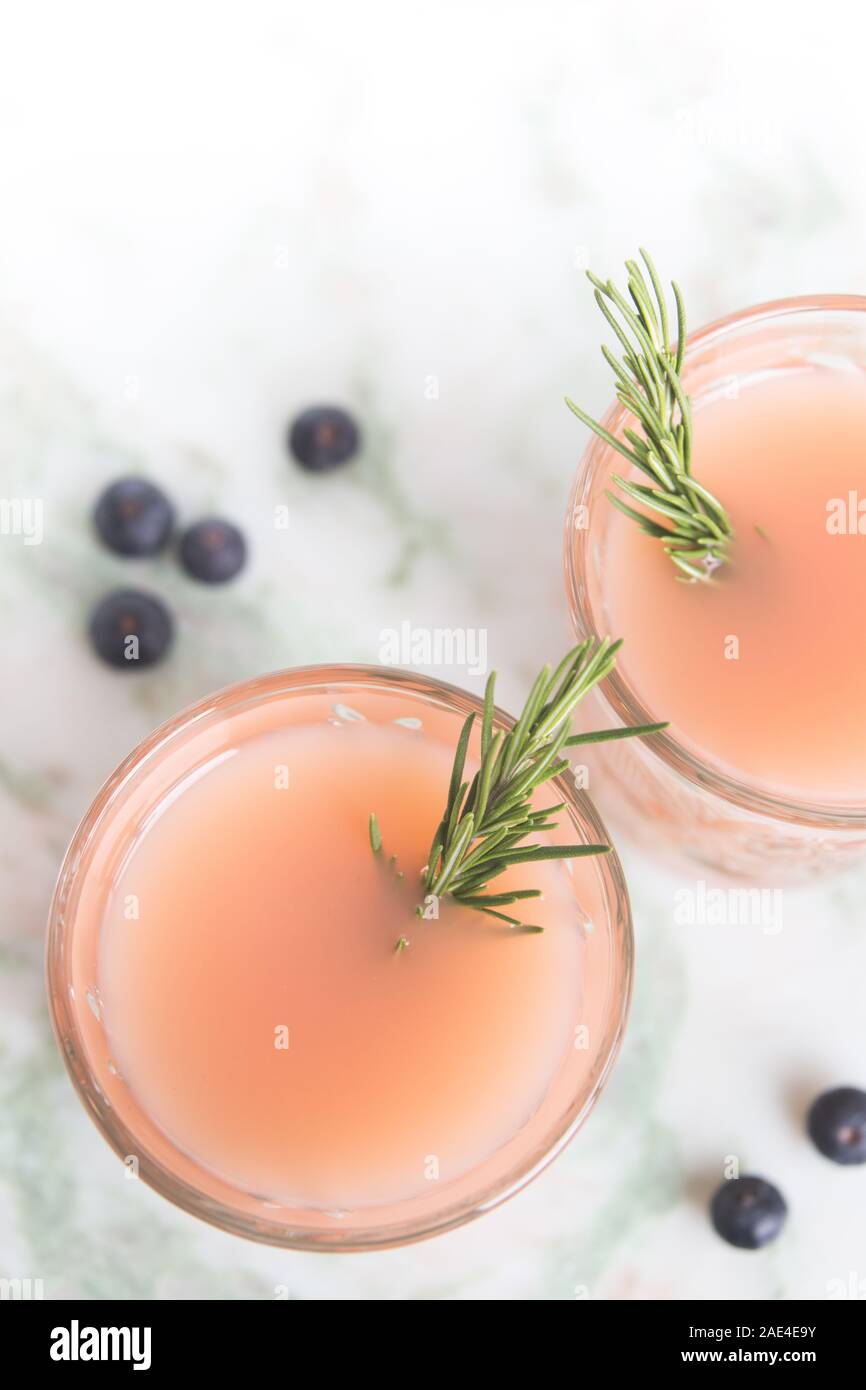 Un cocktail di rosa con un rametto di rosmarino Foto Stock