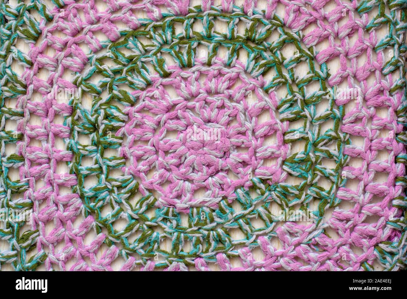 La consistenza del tessuto. Maglia modelli circolare di colore rosa e verde di lana. Foto Stock