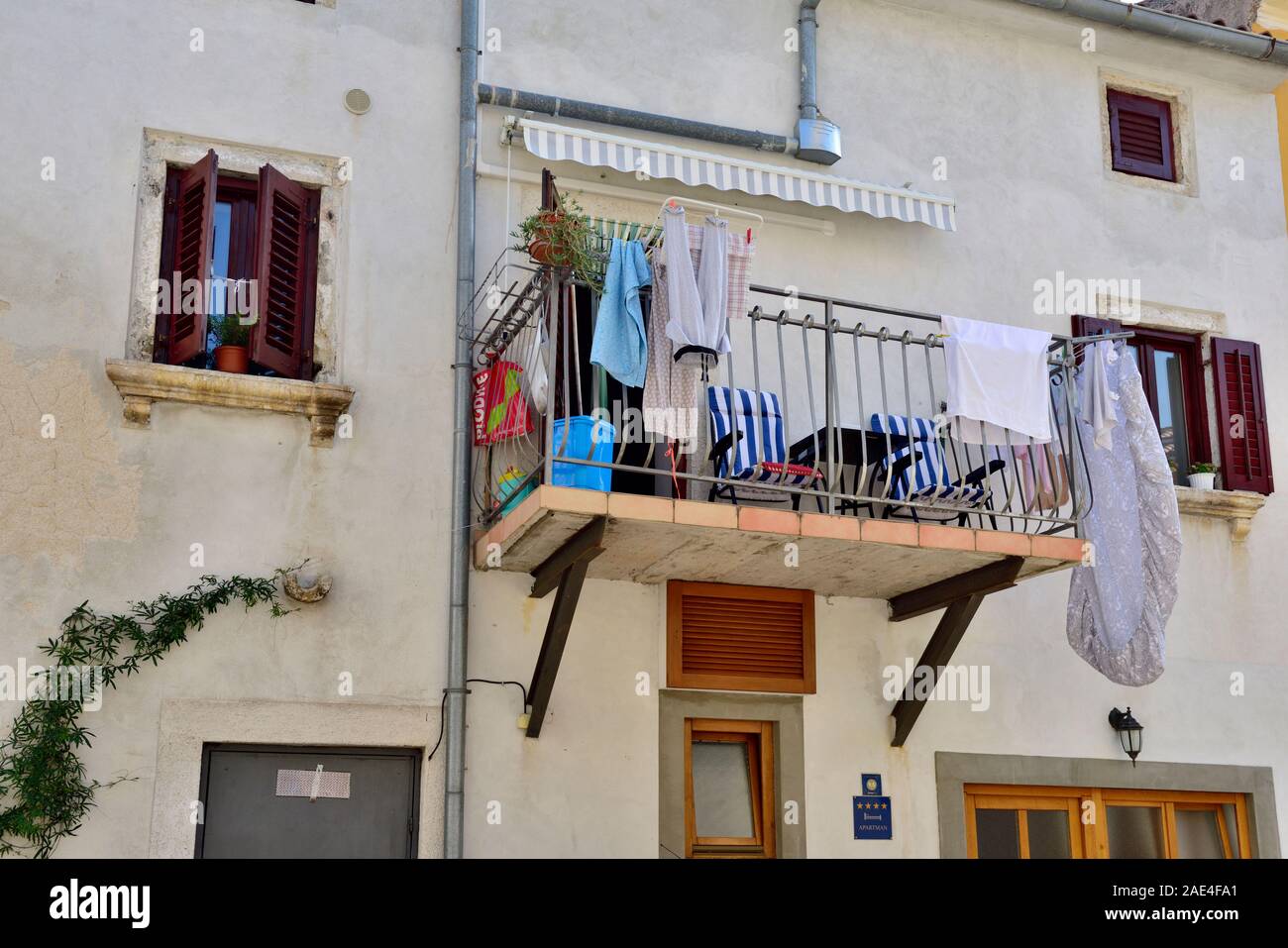Balcone con sedie e servizio lavanderia essiccazione su ringhiere in città vecchia Orsera, Istria, Croazia Foto Stock