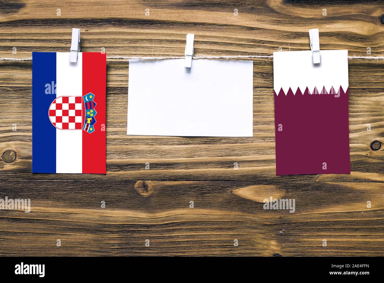 Appendere bandiere di Croazia e il Qatar attaccata alla corda con vestiti perni con copia spazio bianco sulla nota carta su sfondo di legno.Le relazioni diplomatiche essere Foto Stock
