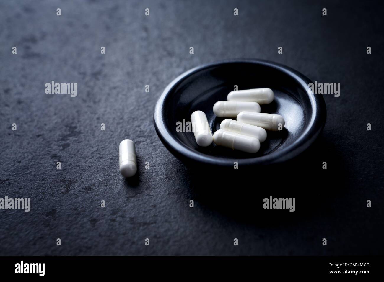 Le capsule di arginina. Bodybuilding integratori alimentari in pietra scura sullo sfondo. Close up. Foto Stock