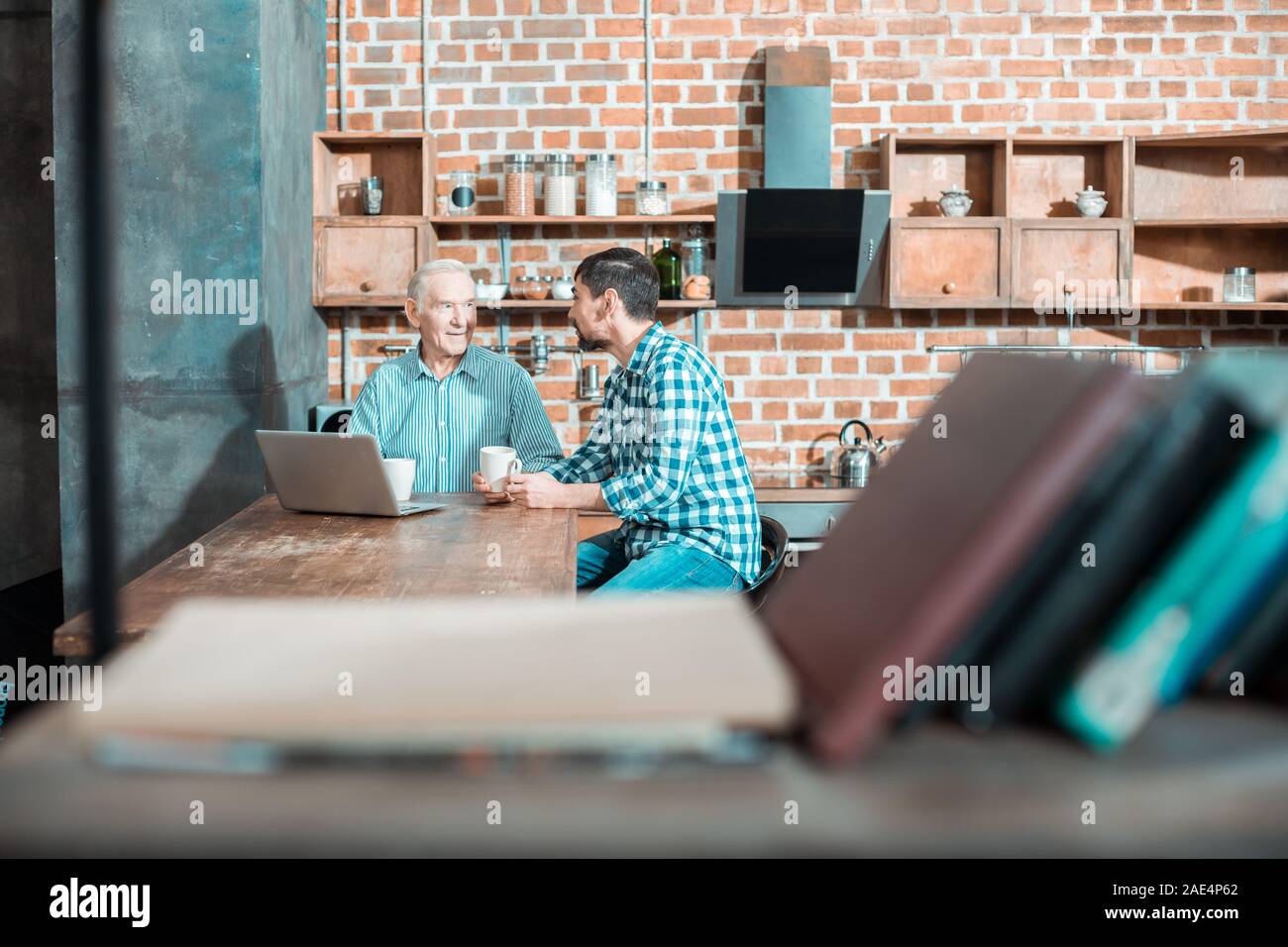Nizza positivo padre e figlio seduti in cucina Foto Stock