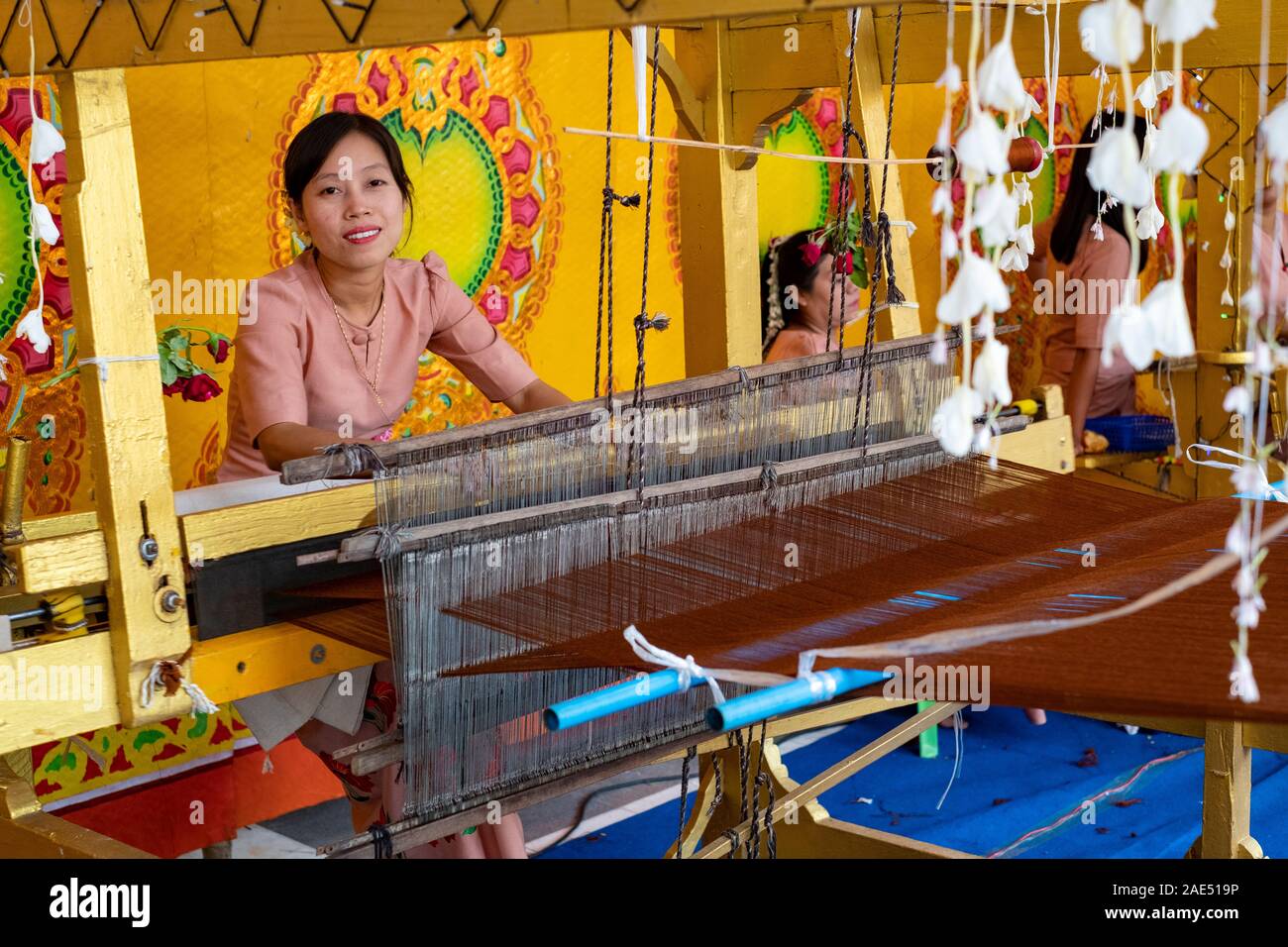 Mostra di donne tessitrici tessitura abiti dello zafferano per i monaci buddisti in un Tempio durante un buddista annuale vacanza a Mandalay, Myanmar (Birmania) Foto Stock