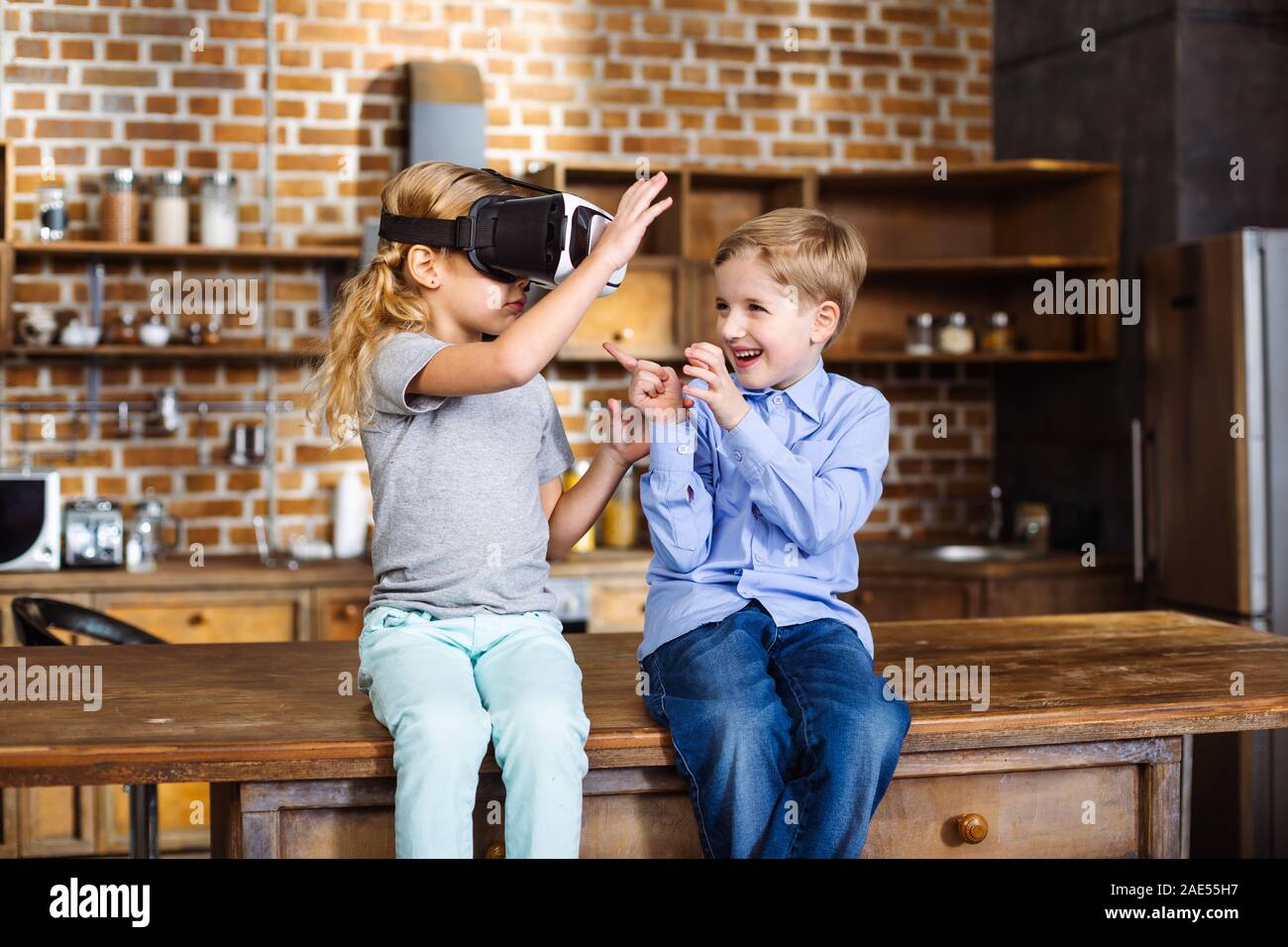 Carino piccoli fratellini uisng occhiali VR Foto Stock