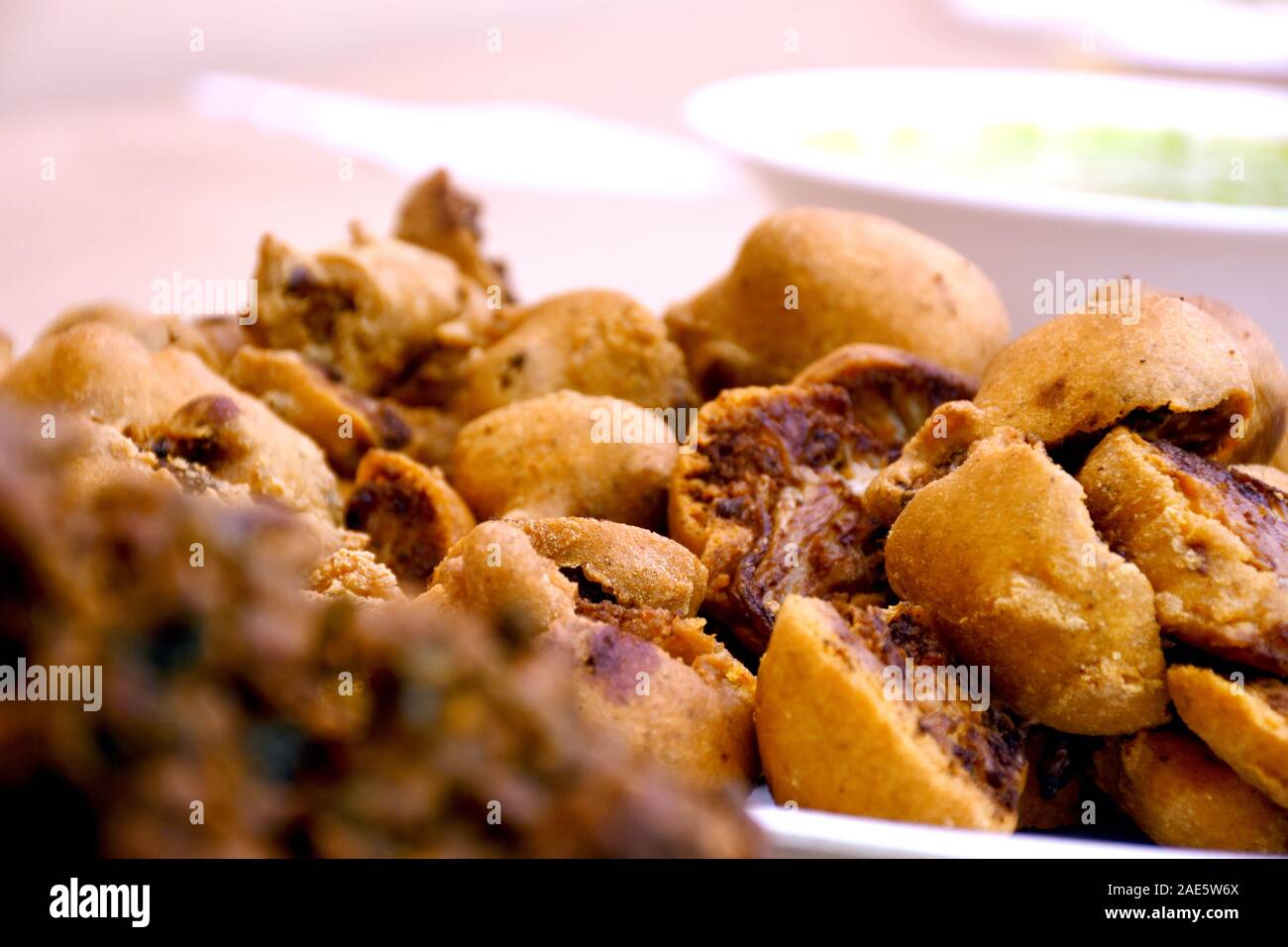 Cipolla croccante bhajis o kanda o pyaj ke pakore o pakoda , delicisous indiano e brasiliano di cibo di strada su insalata, tipicamente goduto in piogge monsoniche / Foto Stock