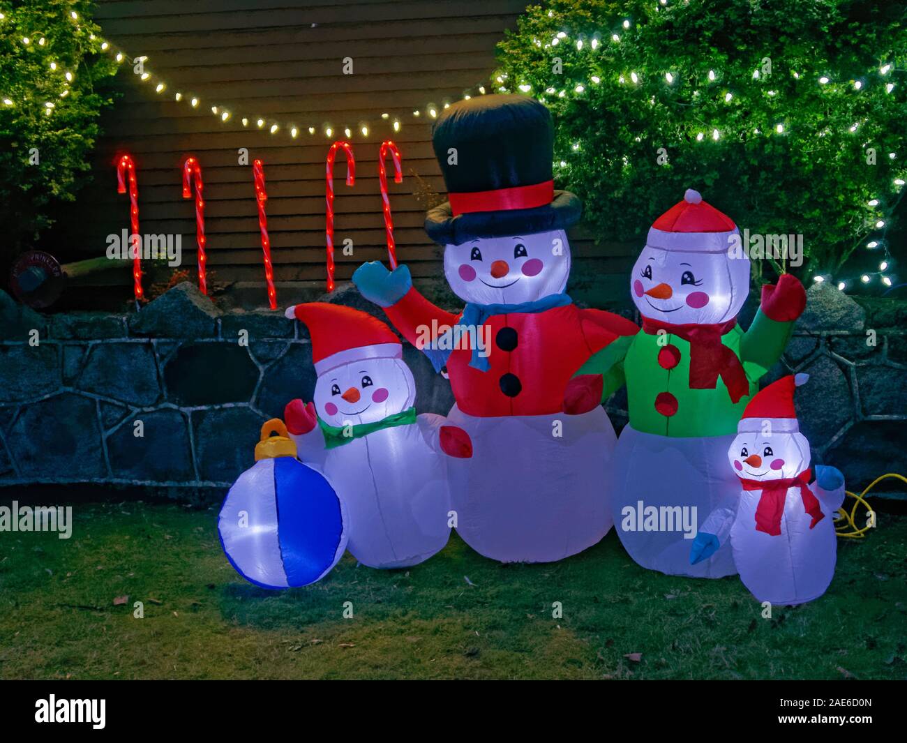 Famiglia di pupazzi di neve le decorazioni di Natale nel cortile anteriore di una casa Foto Stock