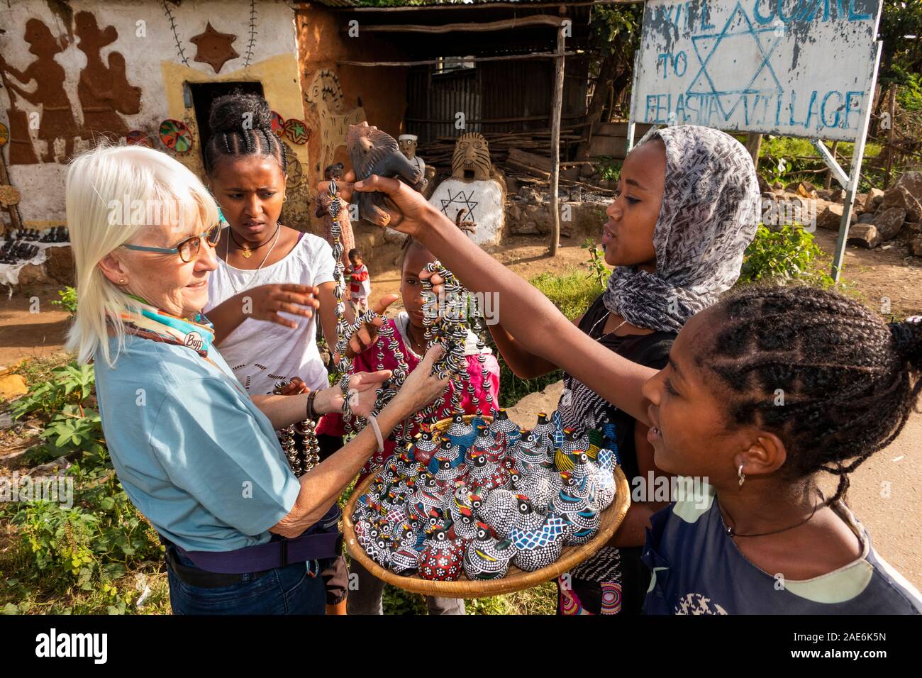 Etiopia, Amhara Region, Gondar, Wolleka Falasha villaggio ebraico, bambini che vendono souvenir al turista senior Foto Stock
