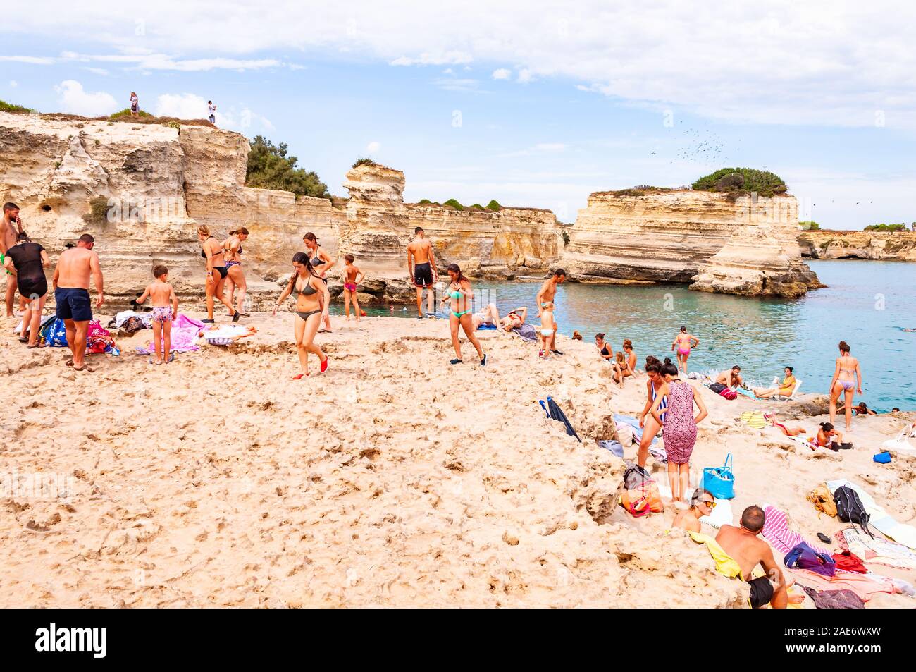 Torre Sant Andrea, Puglia, Italia - 09 Settembre 2019: persone diving dalla scogliera, prendere il sole, nuotare nel mare cristallino dell'acqua sulla spiaggia rocciosa Foto Stock