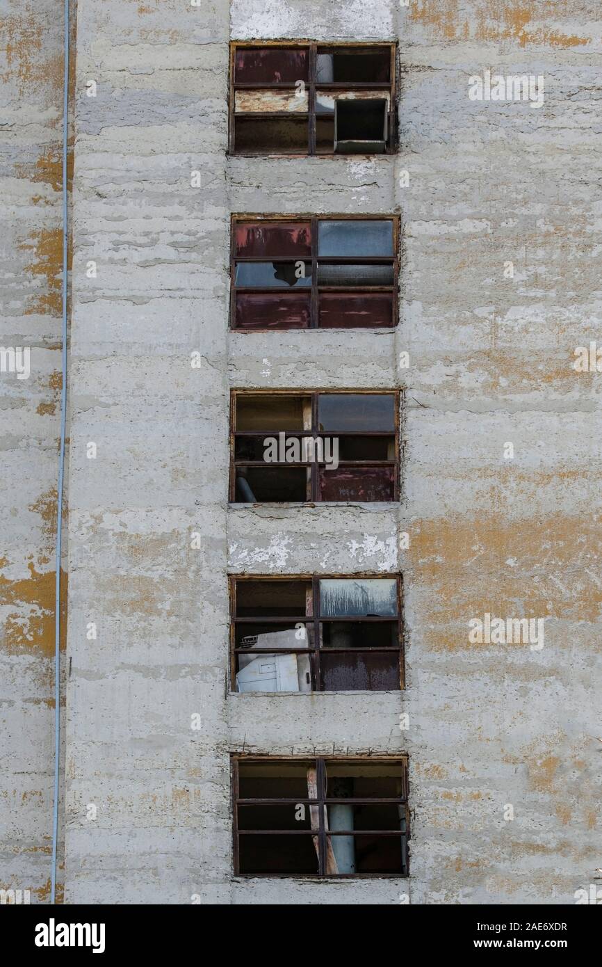 Vecchia fabbrica abbandonata con vetri rotti e stagionato edificio industriale esterno. Le linee principali della composizione del concetto rovinato il passato e il futuro. Foto Stock