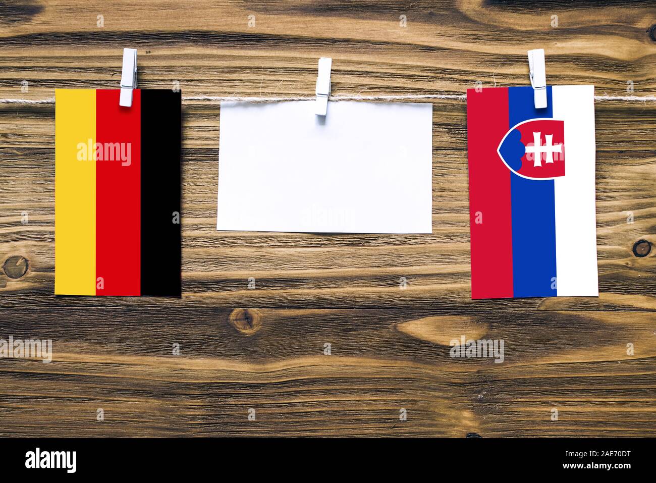 Appendere le bandiere della Germania e Slovacchia attaccata alla corda con vestiti perni con copia spazio bianco sulla nota carta su sfondo di legno.Le relazioni diplomatiche Foto Stock