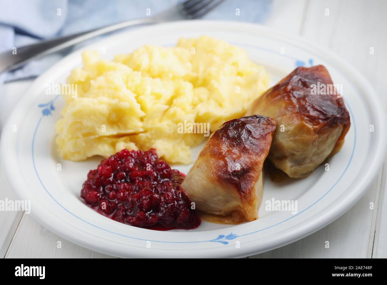 Due finlandesi involtini di cavolo Kaalikaaryleet con purè di patate e marmellata di lingonberry su un tavolo rustico Foto Stock