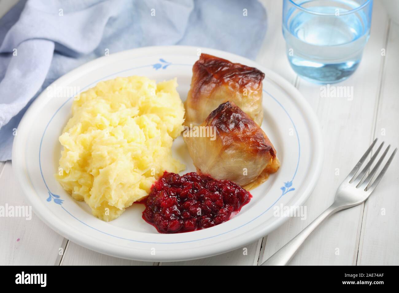 Due finlandesi involtini di cavolo Kaalikaaryleet con purè di patate e marmellata di lingonberry su un tavolo rustico Foto Stock