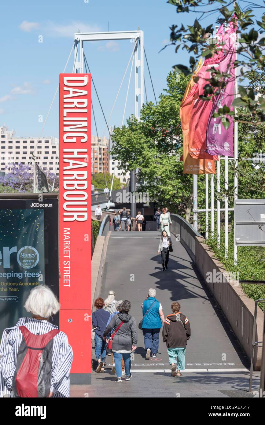 La gente che camminava su uno stretto ponte pedonale che collega CBD di Sydney al Darling Harbour e Darling trimestre ristoranti e intrattenimento perimetro Foto Stock