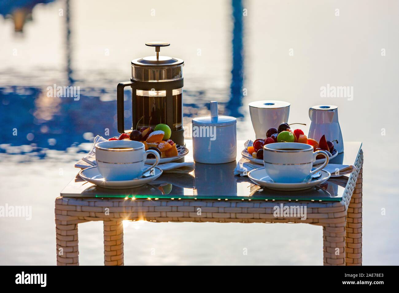 Serve table con succhi di frutta e caffè vicino alla piscina esterna. Foto Stock