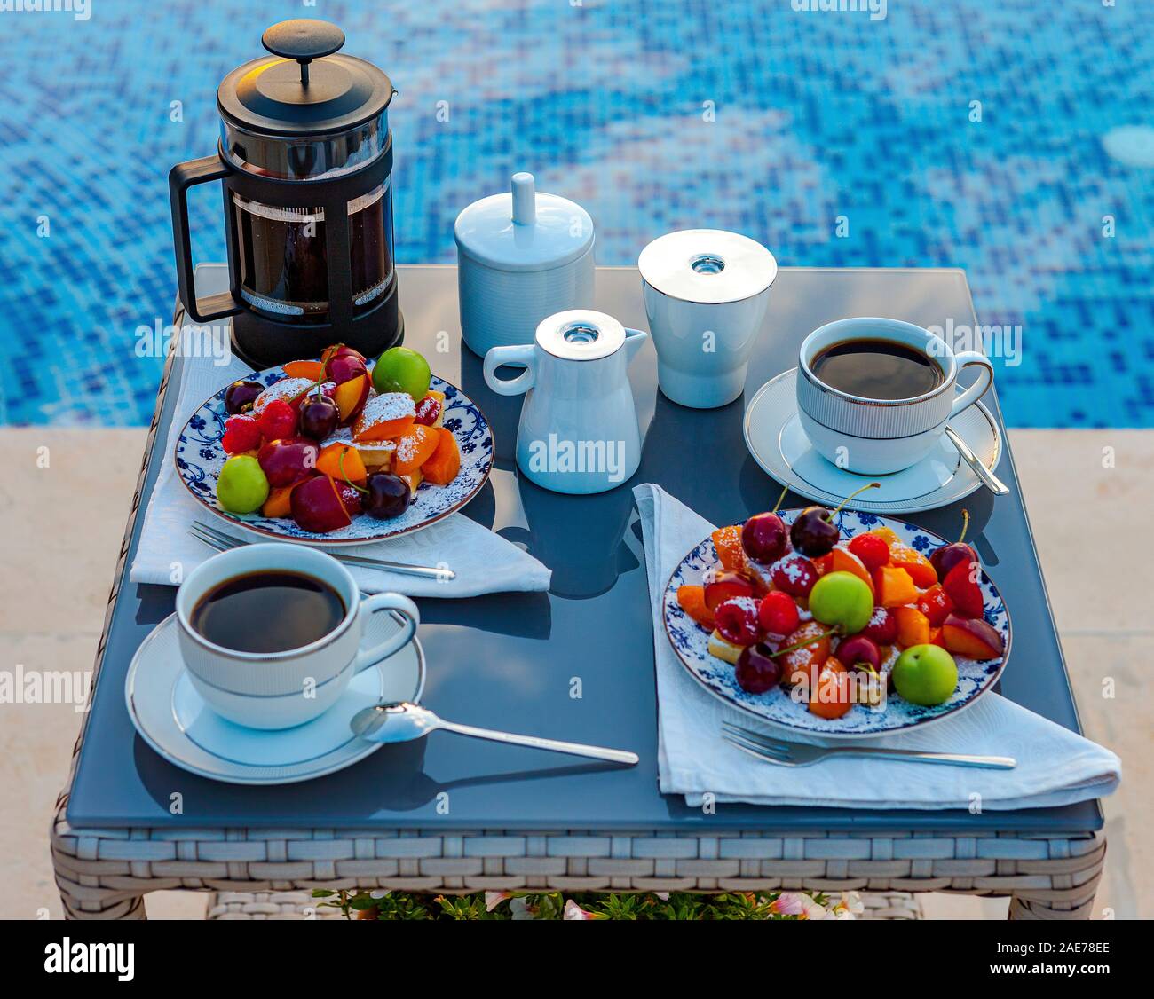 Serve table con succhi di frutta e caffè vicino alla piscina esterna. Foto Stock