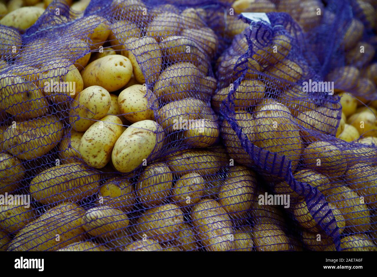 Verdure di stagione sono impilati in scatole presso il negozio di alimentari. Grandi Patate fresche sono in apposite borse di maglia. Prodotti naturali per la cottura sana foo Foto Stock