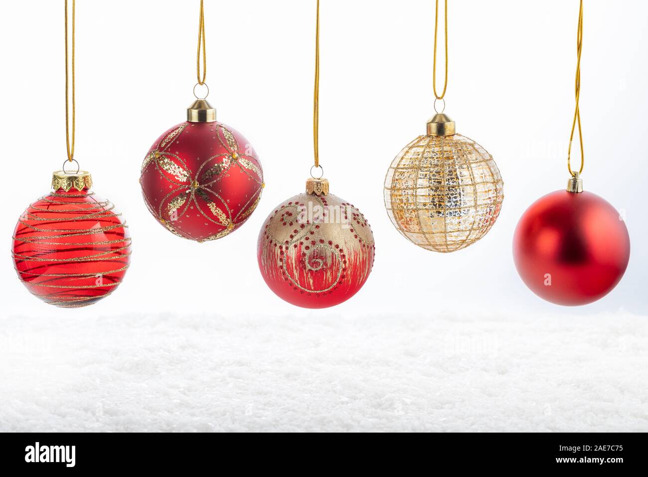 Set di cinque bellissimi Natale rosso e le sfere di oro bianco su sfondo innevato. Buon Natale e Felice Anno Nuovo concetto. Foto Stock