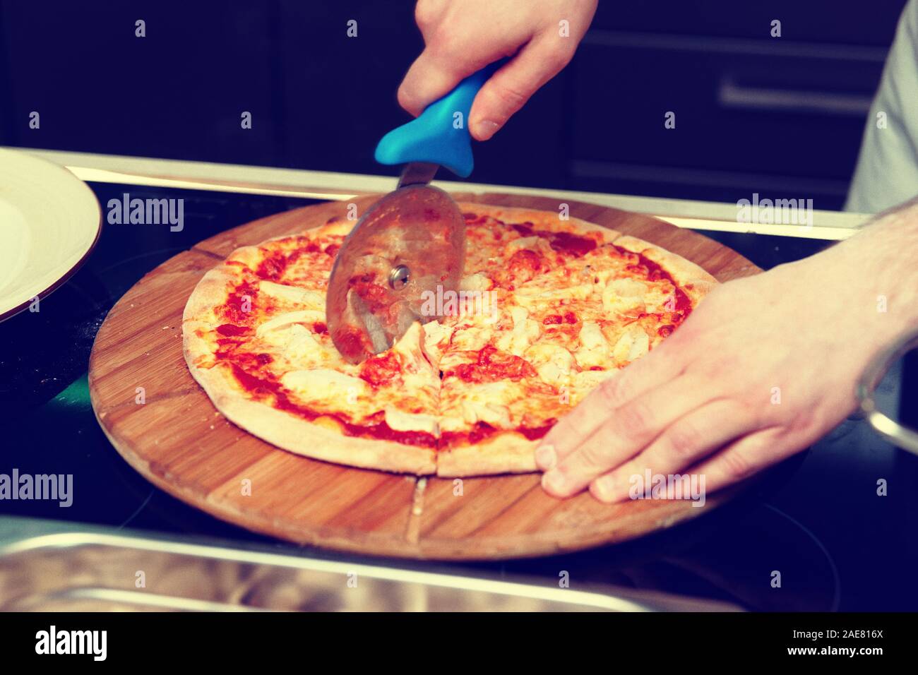 Lo chef è il taglio di pizza in cucina commerciale, tonica immagine, grana di pellicola Foto Stock