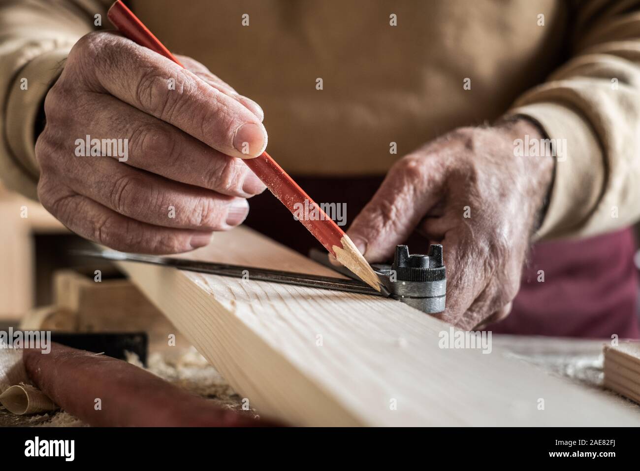 Carpenter la misurazione di una doga con una matita rossa e un righello in metallo Foto Stock