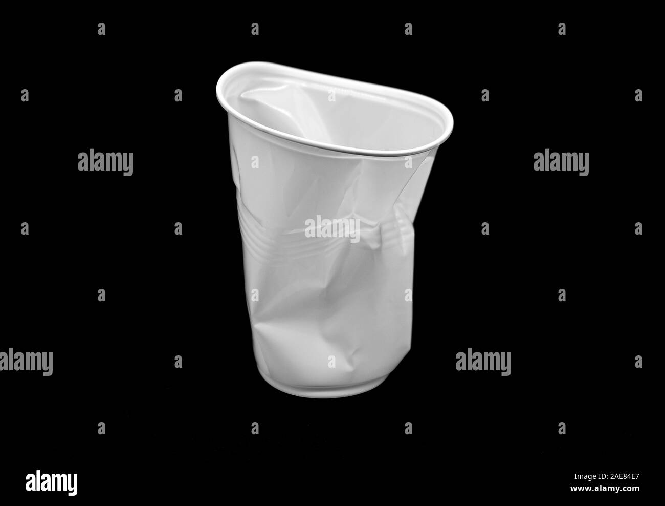 Crumpled bianco in plastica tazza isolata su sfondo nero Foto Stock