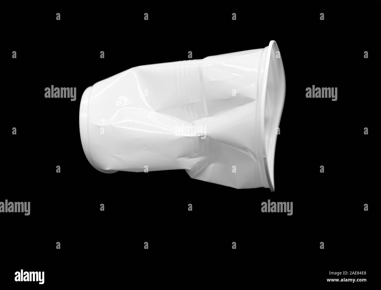 Crumpled bianco in plastica tazza isolata su sfondo nero Foto Stock