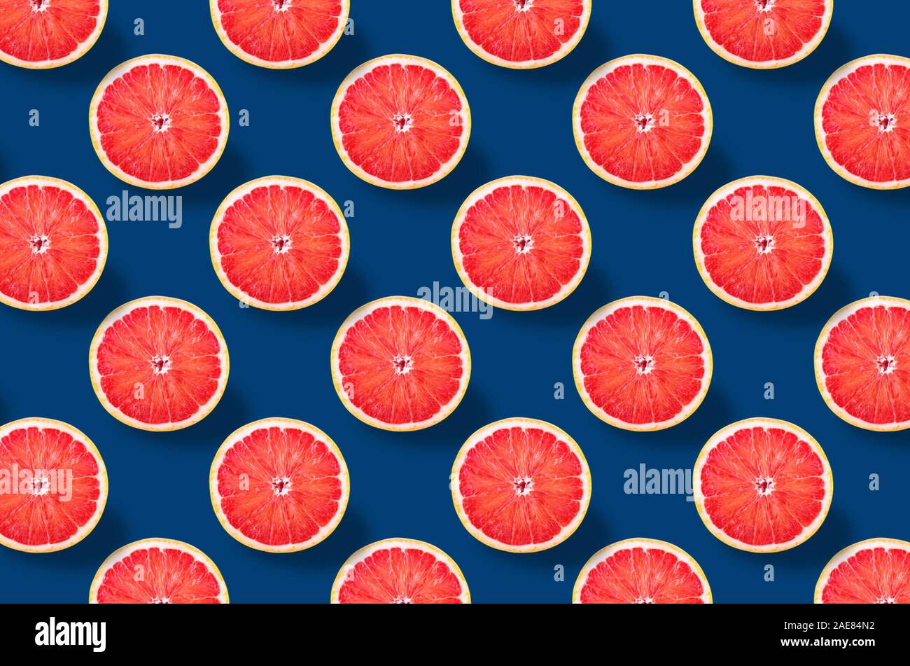 Succo di pompelmo fresco frutta pattern in tonalità blu classico. La minima nozione di cibo per il tuo blog. Dalla vista superiore. tutta la profondità di campo. Foto Stock