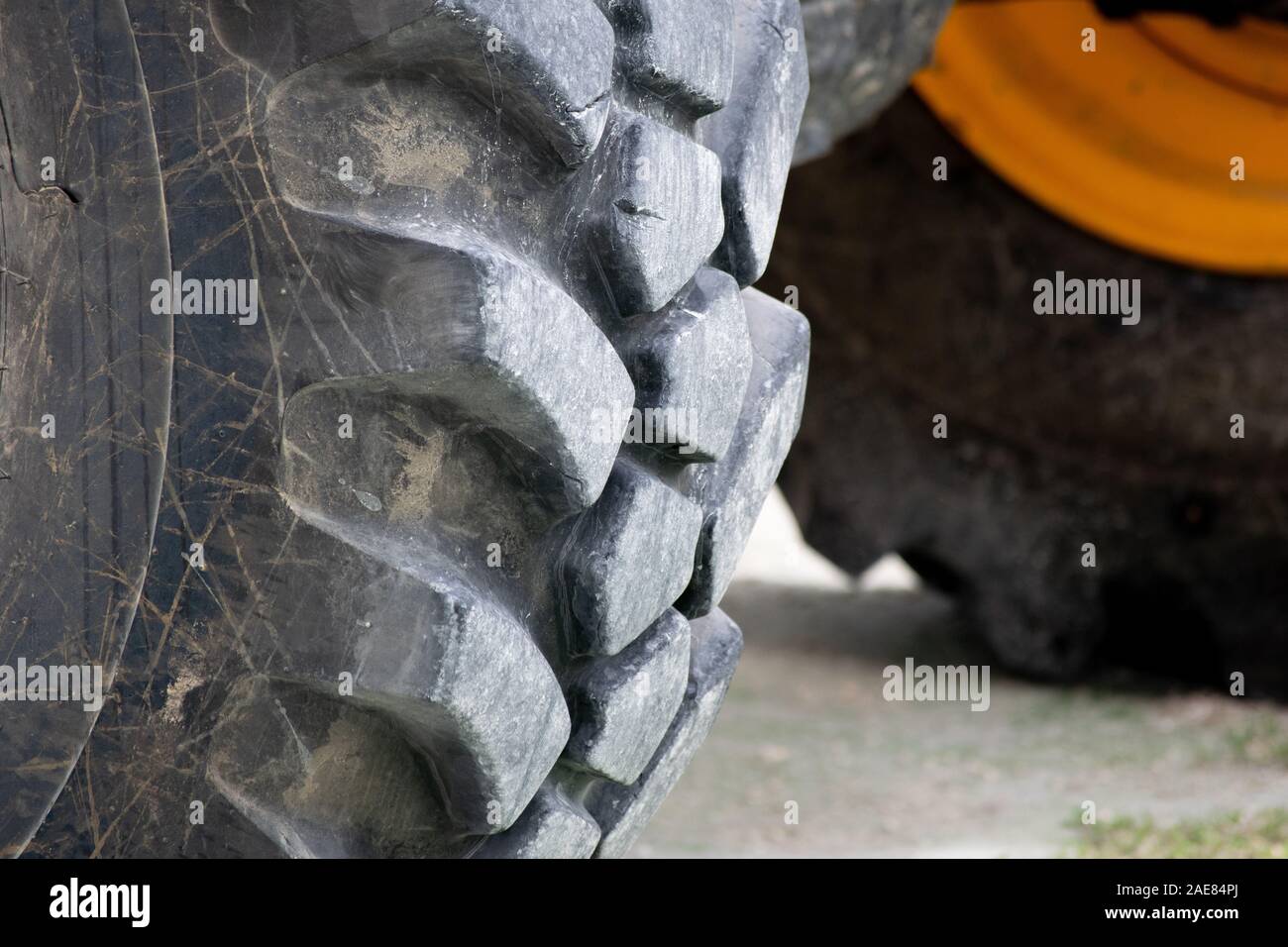 Fino chiudere la vista del pneumatico sul grande giallo il trattore. Foto Stock