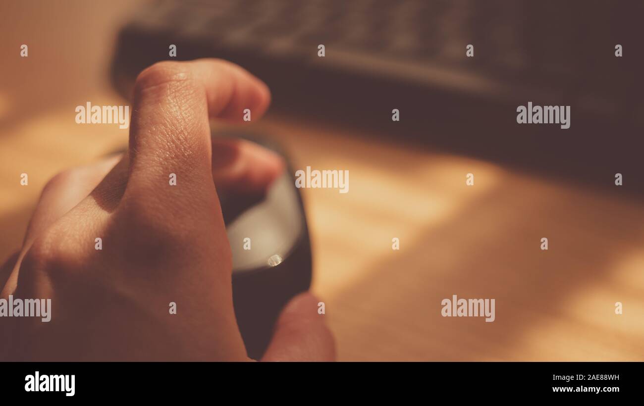 Mano femmina usare il mouse del computer vicino a tastiera desktop soleggiato, il fuoco selettivo sul dito. Foto Stock