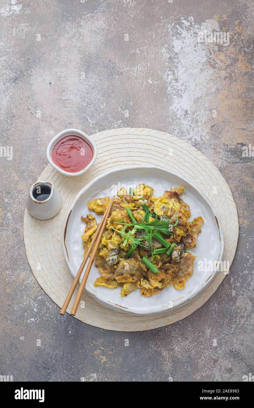 Oyster frittata servita su piastra bianca, cucina asiatica spazio copia Foto Stock