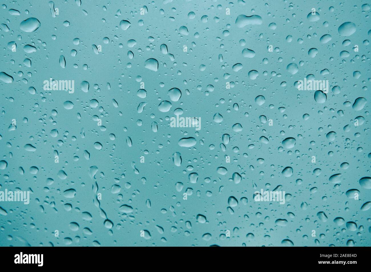 Gocce di pioggia sulla finestra. In autunno la pioggia sul vetro per auto, il fuoco selettivo su raindrop. Foto Stock