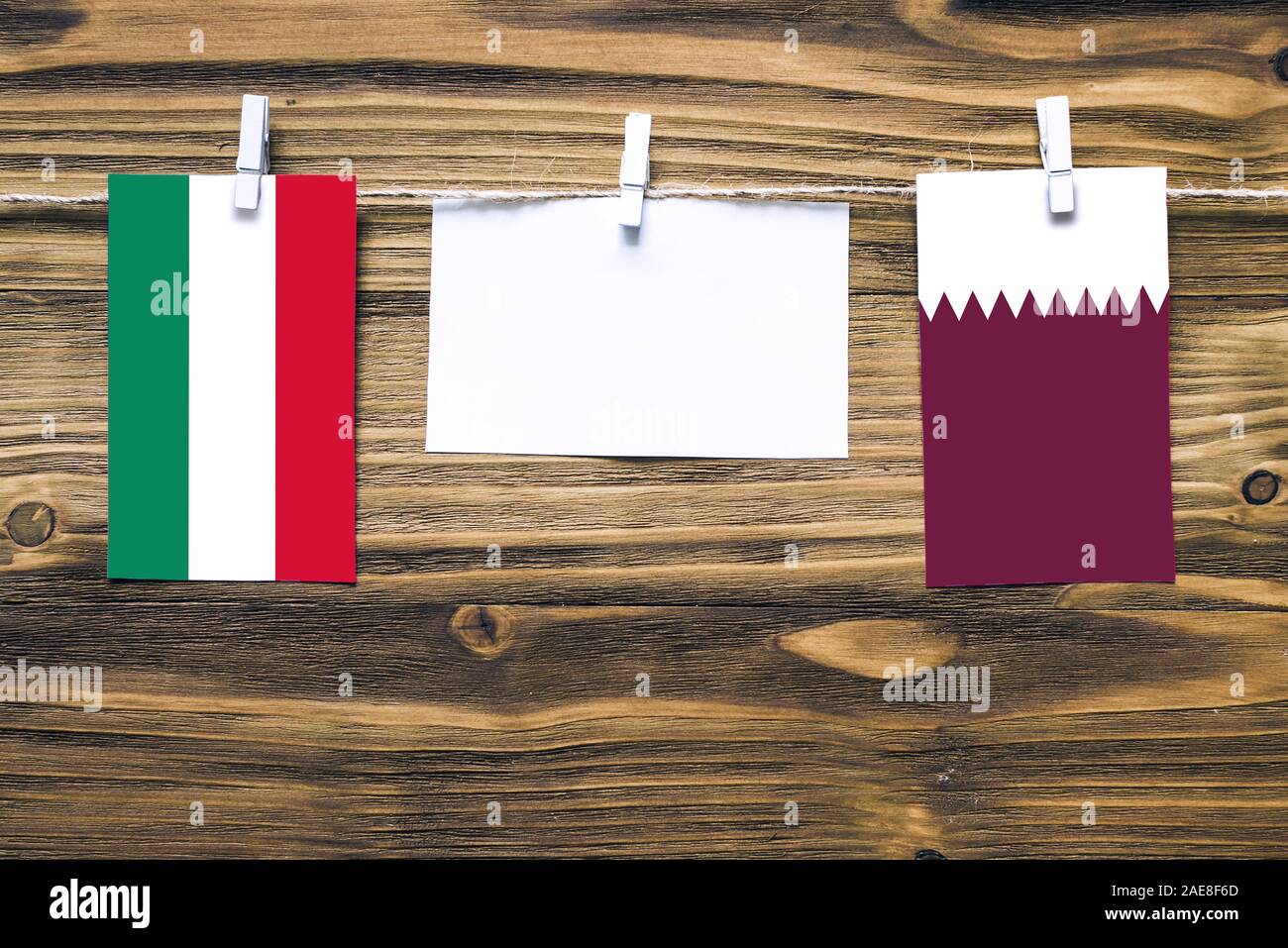 Appendere bandiere di Ungheria e Qatar attaccata alla corda con vestiti perni con copia spazio bianco sulla nota carta su sfondo di legno.Le relazioni diplomatiche essere Foto Stock
