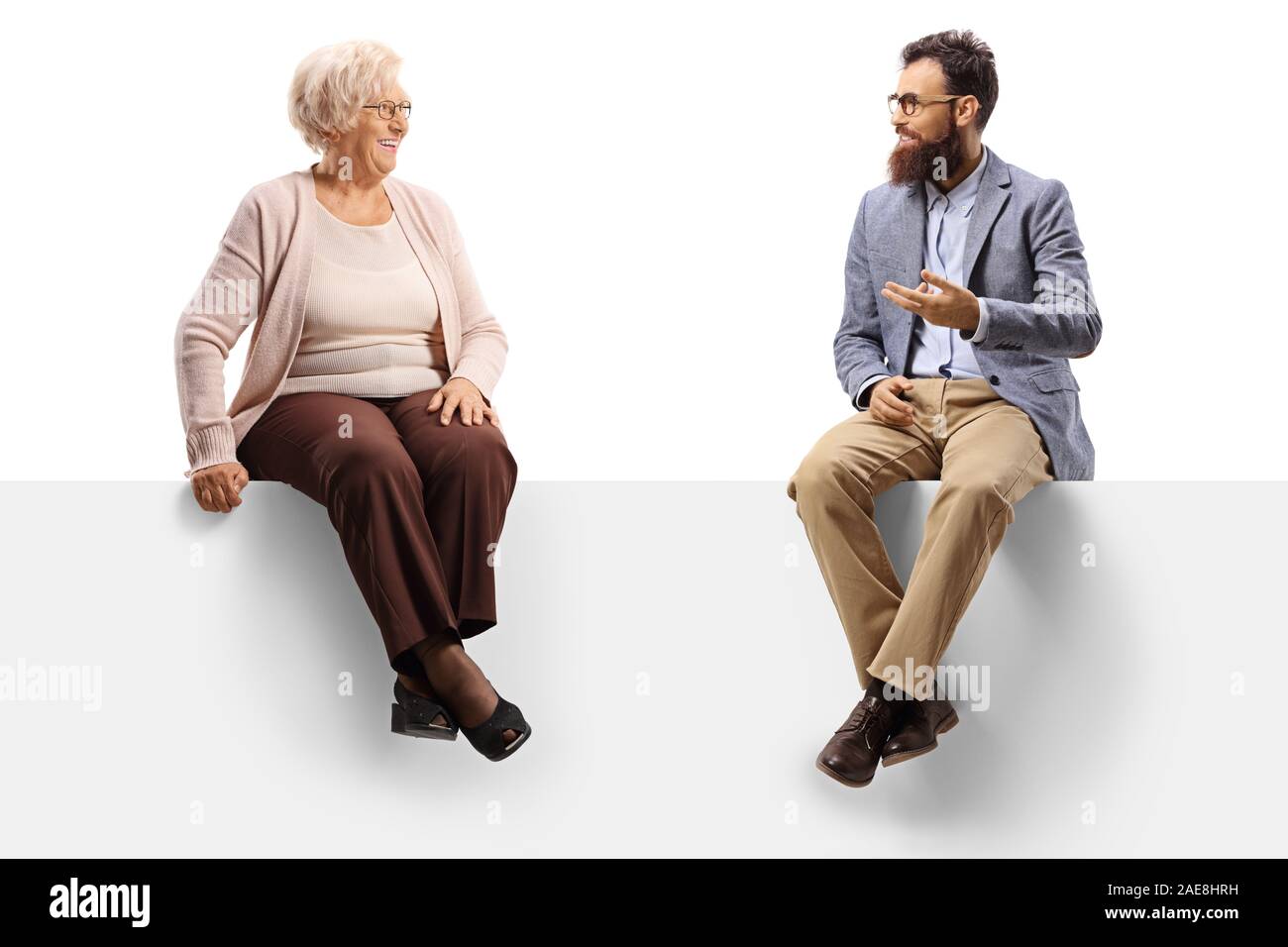 Senior donna e un uomo barbuto seduto su un pannello e parlando isolati su sfondo bianco Foto Stock