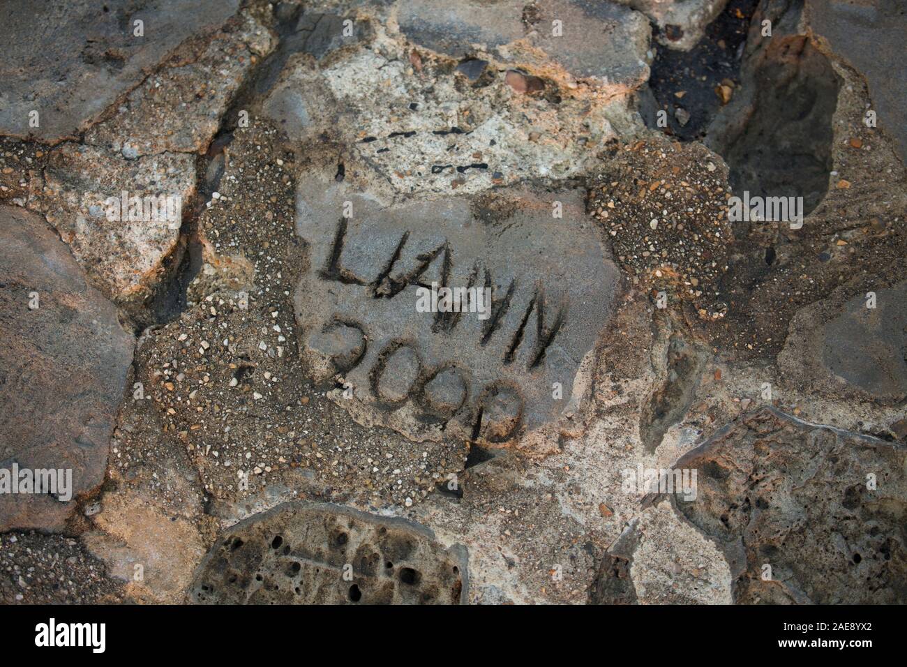 I nomi che sono stati attaccati in cemento su il Cobb a Lyme Regis porto. Lyme Regis è situato sulla costa del patrimonio o Jurassic Coast e la Foto Stock