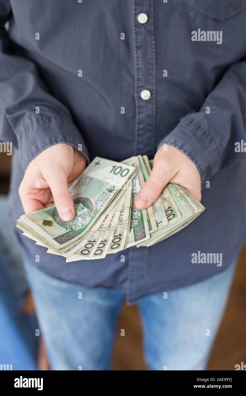 Disoccupati uomo che mostra un sacco di denaro contante da prestazioni sociali: centinaia di zlotys - Polacco denaro Foto Stock