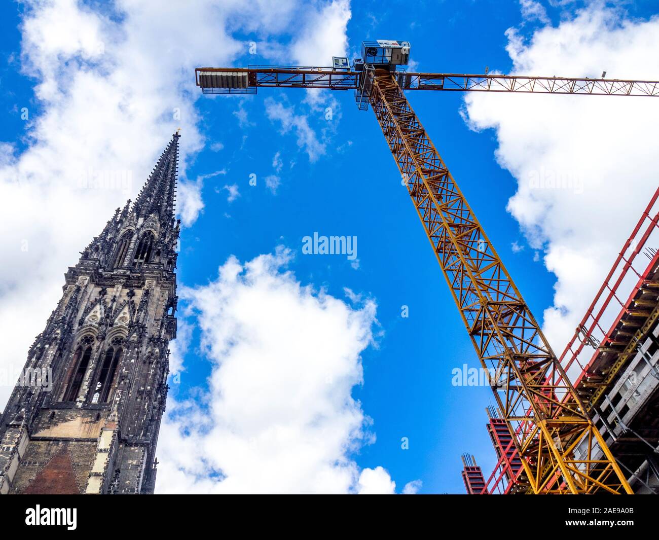 Campanile gotico della chiesa di San Nicola conservato come Monumento della seconda Guerra Mondiale e boom a laticenze e braccio di gru vicino sito di costruzione Amburgo Germania Foto Stock