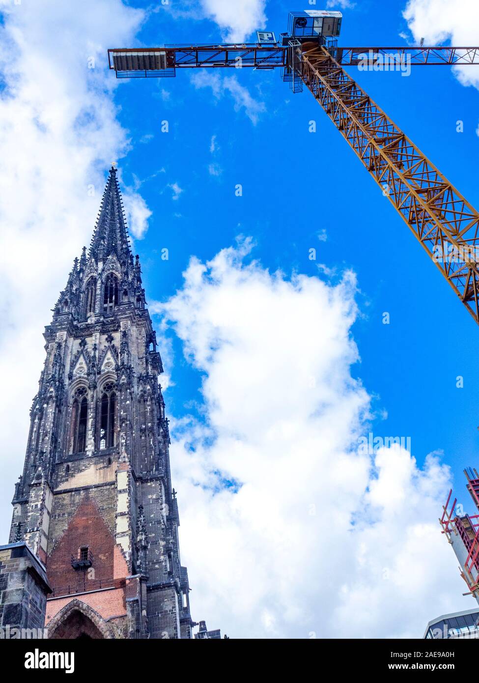 Campanile gotico della chiesa di San Nicola conservato come Monumento della seconda Guerra Mondiale e boom a laticenze e braccio di gru vicino sito di costruzione Amburgo Germania Foto Stock