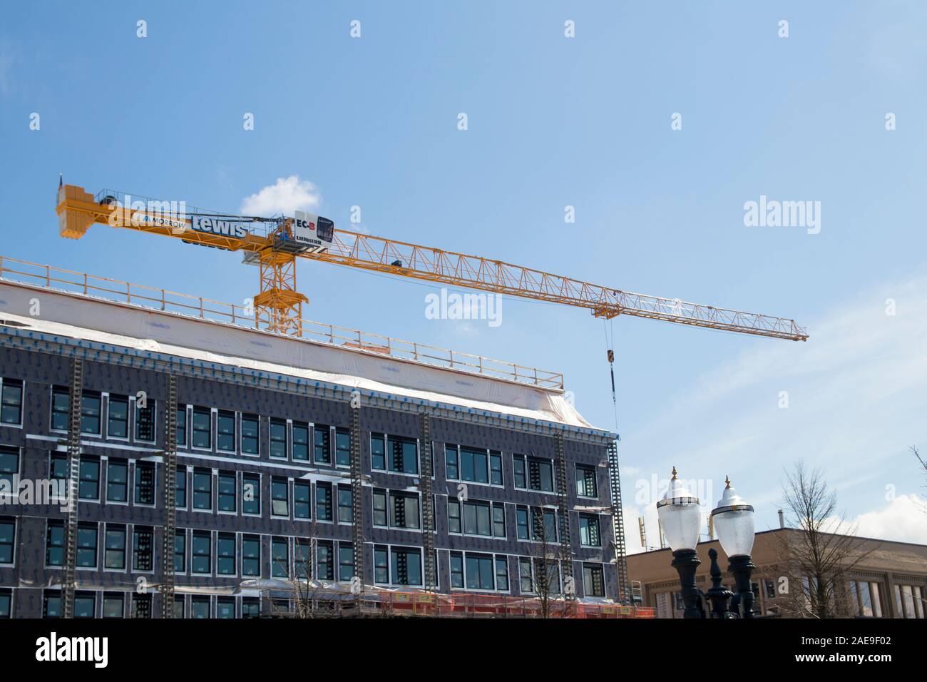 Portland, Oregon / STATI UNITI D'AMERICA - Circa 2019: un giallo gru da cantiere sulla parte superiore di un edificio. Foto Stock